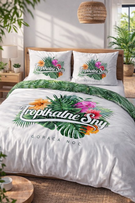 Pościel bawełniana 220x200 cm w kolorze białym z nadrukiem tropikalnych liści, kwiatów oraz napisem Tropikalne Sny. Położona na łóżku z widocznymi poduszkami w tym samym wzorze. Tło jasne, proste, z rośliną w donicy obok.