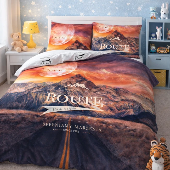 Pościel bawełniana 220x200 cm w motywie górskim z zachodem słońca, z nadrukiem ROUTE na narzucie i poszewkach. Kolory: pomarańczowy, fioletowy i niebieski. Pościel z zamkiem błyskawicznym, rozłożona frontalnie w pięknej sypialni dziecięcej.
