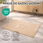 Dywanik łazienkowy 50x70 cm w kolorze cappuccino, z wytłoczonym wzorem stóp. Ułożony na jasnym podłożu, teksturowany, idealny do wanny i pod prysznic. Oeko-Tex, łączący estetykę i funkcję.