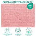 Dywanik łazienkowy 50x70 cm w kolorze ciemnego różu, z fakturą z drobnymi wypustkami oraz wypukłym wzorem stóp. Leżący na jednolitym tle, o prostokątnym kształcie, idealny do użytku w łazience.