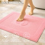 Dywanik łazienkowy 50x70 cm w kolorze ciemnego różu, wykonany z 100% bawełny. Na powierzchni widoczny wzór stópek, grube frotté zapewnia szybkie wchłanianie, a struktura jest przyjemna w dotyku. Produkt leży na jasnej powierzchni.