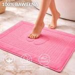 Dywanik łazienkowy 50x70 w kolorze fuksji, o gładkiej fakturze, leżący na podłodze. Otoczenie to nowoczesna łazienka