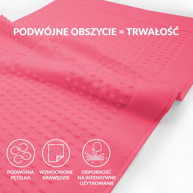 Dywanik łazienkowy 50x70 w kolorze fuksji, o teksturowanej fakturze z wypukłymi punktami. Ułożony leżąco na białym tle, ukazuje detale i wykończenie krawędzi. Nie zawiera widocznych napisów ani logo.
