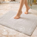 Dywanik łazienkowy 50x70 w kolorze jasno szarym, o gładkiej fakturze, leżący na podłodze. Otoczenie to nowoczesna łazienka