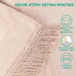 Koc bawełniany 200x220 w jasnym beżu, z frędzlami na jednym boku. Ujęcie w zbliżeniu, pokazujące fakturę materiału oraz detal wykończenia. Produkt leży na gładkiej powierzchni, z prostym tłem.