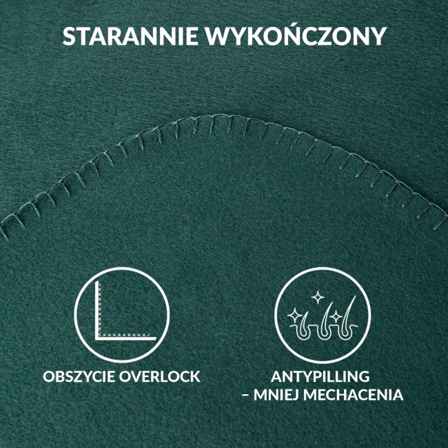 Koc polarowy 150x200 w butelkowej zieleni, leżący na płaskiej powierzchni. Widoczna lekka tekstura materiału oraz delikatne, kontrastowe szwy na obrzeżach. Zbliżenie na detal, uwidaczniające estetyczne wykończenie.