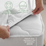 Prześcieradło jersey z gumką w kolorze białym, rozłożone na materacu o wysokości do 20 cm. Zbliżenie na gumkę, która utrzymuje prześcieradło na miejscu. Tło neutralne, podkreślające detal produktu. Widoczne informacje o funkcjonalności i dopasowaniu.