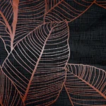 Pościel bawełniana 180x200 w ciemno szarym kolorze z miedzianym wzorem liści. Materiał o gładkiej fakturze, ukazujący detale liści w odcieniach miedzi, na tle w kratę. Produkt leży na płaskiej powierzchni, prezentując wzór.