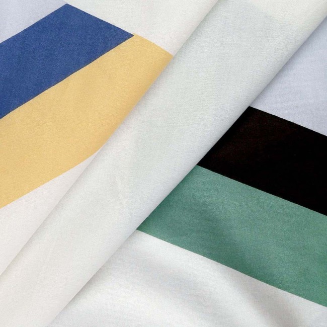 Pościel bawełniana 140x200 Rytm w odcieniach bieli z kolorową geometrią, w tym niebieskimi, żółtymi i zielonymi pasami. Materiał gładki, w zbliżeniu na detale wzoru, leżący na sobie.