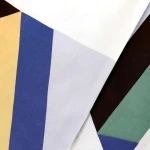 Pościel bawełniana 160x200 Rytm w kolorową geometrię, z widocznymi prostokątami w odcieniach bieli, niebieskiego, żółtego, zielonego i brązowego. Materiał gładki, ułożony w sposób ukazujący różnorodne kolory i kształty.