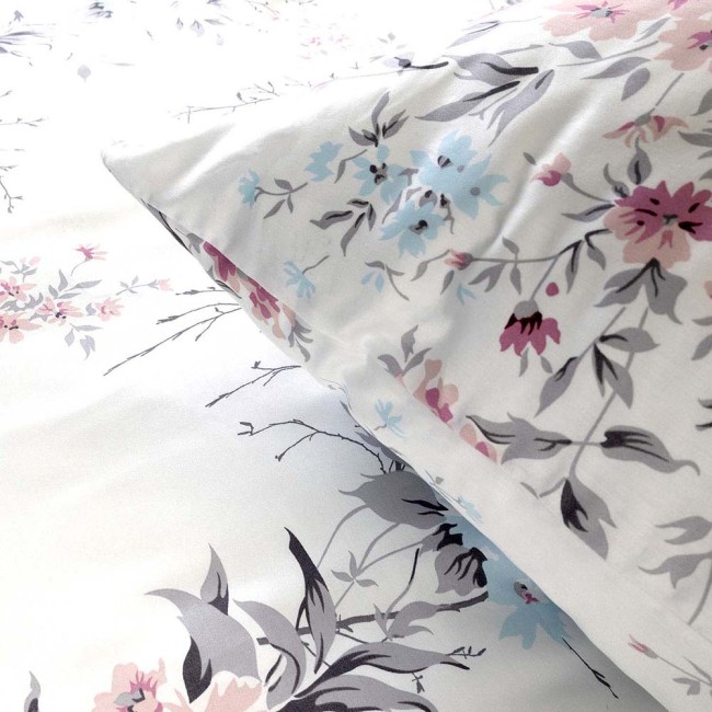 Pościel satynowa 200x220 cm w kolorze białym z wiosennym wzorem różowych i niebieskich kwiatów. Widoczne poduszki i poszwa, materiał gładki, z delikatnym połyskiem. Ułożona na płaskiej powierzchni, prezentująca szczegóły nadruku.