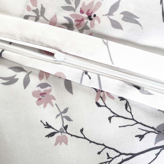 Pościel satynowa bawełniana 200x220 w białym kolorze, zdobiona wiosennymi różowymi i niebieskimi kwiatami. Widoczne zamknięcie na zamek błyskawiczny. Motyw kwiatowy na tle z gałązkami.