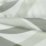 Pościel satyna bawełniana 160x200 w odcieniach zieleni, z dekoracyjnym wzorem liści. Materiał gładki, lekko błyszczący, ułożony w złożony sposób, eksponujący detale wzoru i fakturę.