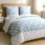 Pościel bawełniana 160x200 w niebiesko-białą kratę, z ozdobnym paskiem. Zestaw składa się z poduszki i narzuty, układ na łóżku z jasnym drewnianym wezgłowiem. Tło w odcieniu beżu, z naturalnym światłem wpadającym przez okno.