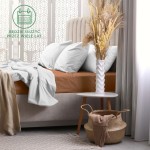 Prześcieradło frotte z gumką 70x160 w kolorze czekoladowym, rozłożone na łóżku, z widocznymi jasnoszarymi poduszkami. W tle jasne zasłony i stylowa waza z suszonymi kwiatami na białym stoliku.