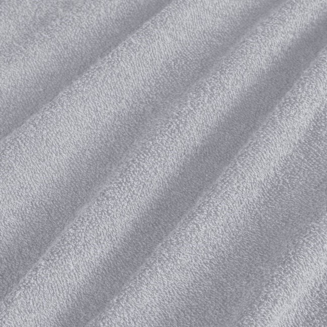 Pościel frotte 135x200 w kolorze jasno szarym, z teksturą pętelkową. Ułożona w lekki sposób, ukazująca miękkość i przyjemność w dotyku materiału. Tło jest jednolite, co podkreśla kolorystykę produktu.