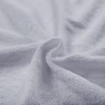 Pościel frotte w kolorze jasno szarym, o wymiarach 135x200 cm. Widoczna tekstura materiału z pętelkami, układająca się w falistą formę. Produkt leży na gładkiej powierzchni, w zbliżeniu na detale materiału.