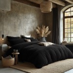 Pościel frotte 135x200 w kolorze czarnym, rozłożona na łóżku z poduszkami w różnych odcieniach, na tle surowej ściany. W pokoju widoczne elementy dekoracyjne, takie jak rośliny i lampy. Ułożenie produktu w stylowej aranżacji sypialni.