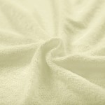 Pościel frotte 135x200 w kolorze kremowym, wykonana z miękkiego, teksturowanego materiału. Widoczne sploty tkaniny, delikatna powierzchnia, leżąca w falach, co podkreśla jej elastyczność i komfort.