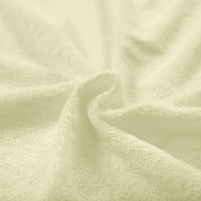 Pościel frotte 135x200 w kolorze kremowym, wykonana z miękkiego, teksturowanego materiału. Widoczne sploty tkaniny, delikatna powierzchnia, leżąca w falach, co podkreśla jej elastyczność i komfort.
