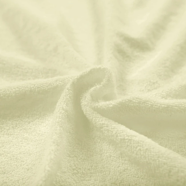 Pościel frotte 155x220 w kolorze kremowym, o miękkiej, teksturowanej powierzchni. Ułożona w falisty sposób, ukazująca delikatny splot materiału, idealna do eleganckich aranżacji sypialni.