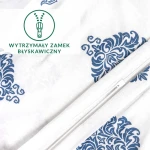 Pościel bawełniana 135x200 z niebieskim ornamentem na białym tle, z widocznym wytrzymałym zamkiem błyskawicznym. Produkt leży na płasko, ukazując wzór oraz teksturę materiału jersey. Tło jest jasne, co podkreśla detale.