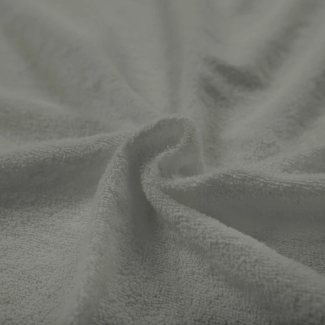 Poszewka frotte 80x80 w kolorze szarym, wykonana z miękkiego materiału o teksturowanej powierzchni. Złożona w delikatne fałdy, eksponuje swoją przyjemną fakturę i neutralny odcień.