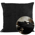 Poszewka frotte 40x80 cm w kolorze czarnym, o teksturowanej powierzchni. Zbliżenie na poszewkę w kontekście aranżacji sypialni, z innymi poduszkami i dodatkami. Tło neutralne, co podkreśla produkt.