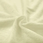 Poszewka frotte 40x80 w kolorze kremowym, wykonana z miękkiego materiału o teksturze frotte, z widocznymi włóknami. Ułożona w luźny sposób, podkreślająca swoją elastyczność i delikatność.