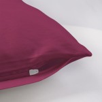 Poszewka satynowa 80x80 w kolorze jasnego fioletu, leżąca na białym tle. Zamek błyskawiczny jest widoczny w dolnej części poszewki. Materiał gładki, jedwabisty, bez wzorów, prezentujący jednolitą barwę.