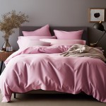 Poszewka satynowa 80x80 w kolorze wrzosowym, ułożona na łóżku z minimalistyczną pościelą. Frontalny kąt ujęcia, ukazujący gładką fakturę. Obok widoczne poduszki w pasujących odcieniach oraz lekki koc w neutralnym kolorze. Tło w tonacji szaro-beżowej.