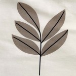 Pościel satynowa w kolorze białym, o wymiarach 220x200 cm, z geometrycznym wzorem w beżu i czerni. Na tle widoczny detal liścia z delikatnymi odcieniami brązu, wyraźnie konturowany czarnymi liniami.