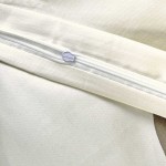 Pościel satynowa w kolorze białym z geometrycznym wzorem w beżu i czerni, z widocznym zamkiem błyskawicznym. Materiał bawełniany o gładkiej fakturze, idealna do łóżka o wymiarach 220x200 cm.