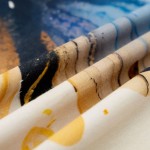 Pościel satyna bawełniana w kremowym kolorze z niebieskimi motylami, złożona i leżąca na stole. Wzór obejmuje różne odcienie niebieskiego i brązowego, w tym detale motyli. Materiał jest gładki, o matowej fakturze.