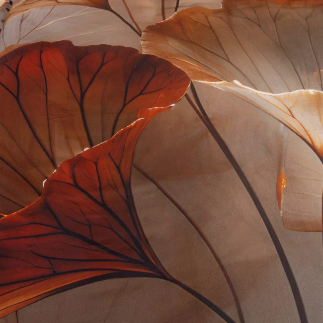 Beżowa pościel satyna bawełniana 200x200 Satynlove Premium z motywem liści. Zbliżenie na detale wzoru, wyraźne kontury liści w odcieniach brązu i pomarańczu na jasnym tle. Produkt leży na płasko, uwydatniając teksturę i kolory materiału.