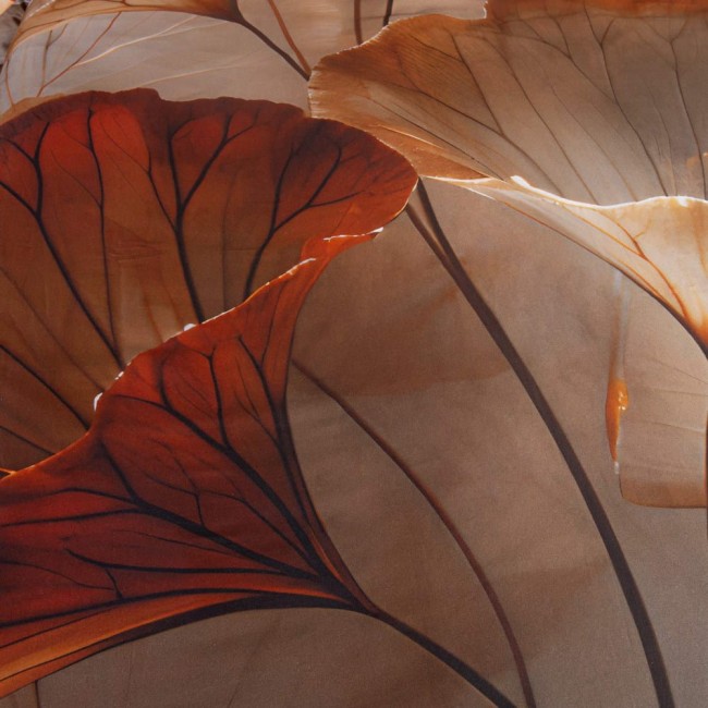 Beżowa pościel satyna bawełniana 220x200 Satynlove Premium z motywem liści. Zbliżenie na detale wzoru, wyraźne kontury liści w odcieniach brązu i pomarańczu na jasnym tle. Produkt leży na płasko, uwydatniając teksturę i kolory materiału.