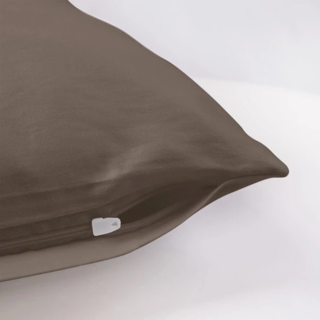 Poszewka satynowa 70x80 w kolorze sepia, leżąca na białym tle. Z widocznym zamkiem błyskawicznym w białej barwie. Gładka, błyszcząca faktura materiału, idealna do stylizacji sypialni.