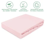 Prześcieradło jersey z gumką 60x120 w kolorze różu kwarcowego, leżące na gładkiej powierzchni. Produkt ma matową, miękką fakturę, idealnie dopasowującą się do materaca. Brzegi prześcieradła są wykończone gumką, co zapewnia stabilność.