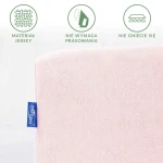 Różowe prześcieradło jersey z gumką, rozmiar 60x120, leży płasko. Widoczny detal etykiety marki Darymex. Materiał jest gładki, nie wymaga prasowania oraz nie gniecie się. Tło jest jasne i proste.