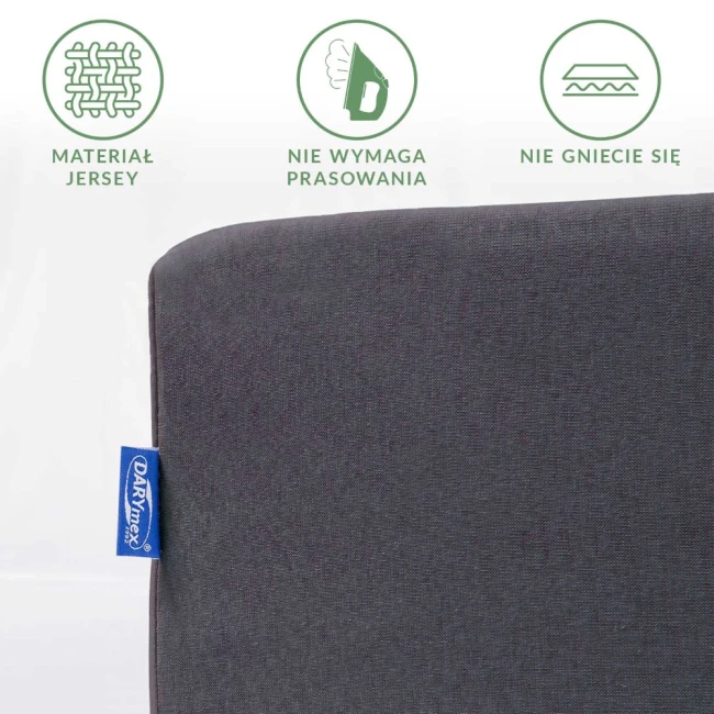 Prześcieradło jersey z gumką w kolorze antracytowym, rozmiar 70x140, z detalem metki. Materiał nie wymaga prasowania i nie gniecie się. Produkt leżący na białym tle, pokazujący strukturę tkaniny.