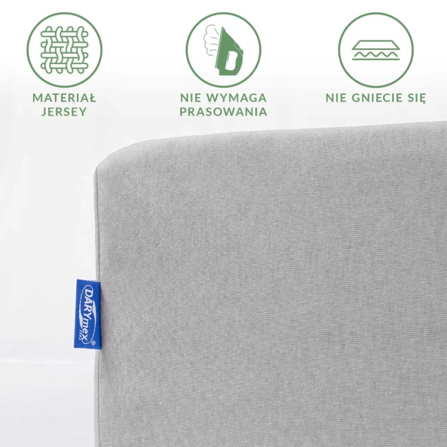 Prześcieradło jersey w kolorze popielatym o wymiarach 70x140 cm. Widoczny fragment z logo, ukazujący gładką fakturę materiału, który nie wymaga prasowania. Ujęcie frontalne, na jednolitym tle, bez dodatków.