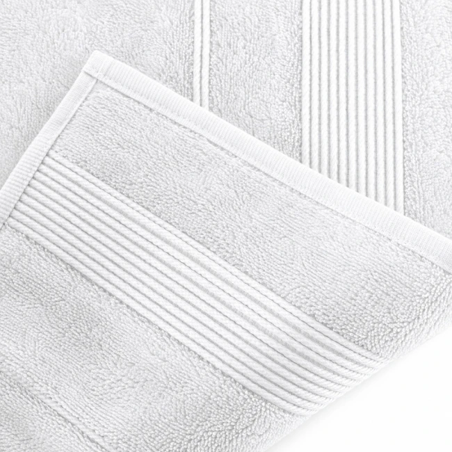 Ręcznik bambusowy 50x90 cm w kolorze białym, leżący na powierzchni. Widoczna struktura tkaniny z delikatnymi przeszyciami na brzegach. Materiał o gładkiej fakturze, idealny do codziennego użytku.