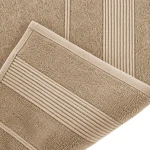 Ręcznik bambusowy 50x90 cm w kolorze cappuccino, z teksturą miękkiego materiału, widoczny z bliska. Zdobienia w postaci poziomych przeszyć na jednym końcu, z elegancką lamówką. Produkt leży na płaskiej powierzchni, na jasnym tle.