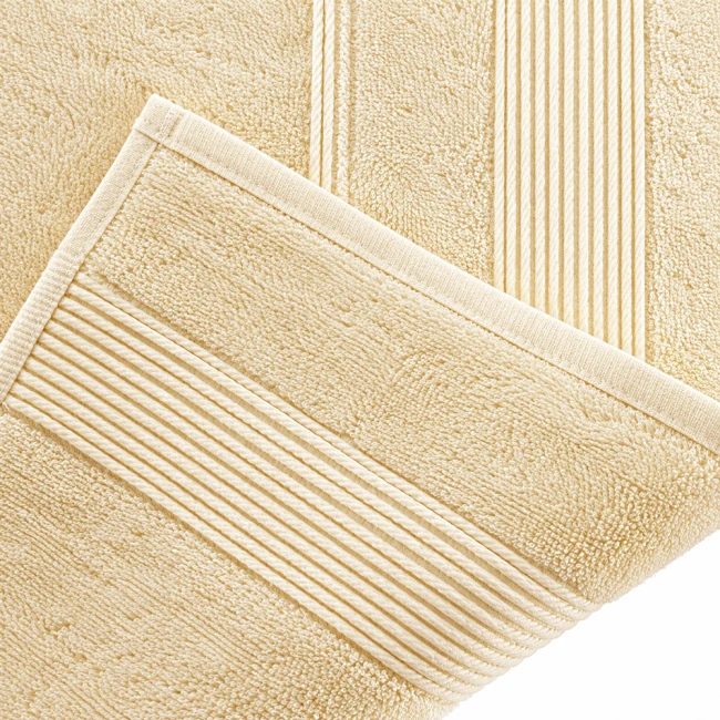 Ręcznik bambusowy 70x140 w kolorze kremowym, z teksturą pętelkową. Położony na białym tle, widoczny brzeg z delikatnym, prostym przeszyciem. Produkt rozłożony, eksponujący całą długość oraz fakturę materiału.