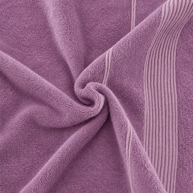 Ręcznik bambusowy 70x140 w kolorze lawendy, leżący, z delikatną fakturą. Widoczne pionowe przeszycia wzdłuż jednego z boków. Produkt wykonany z włókien bambusowych, charakteryzuje się wysoką chłonnością. Tło jednolite.