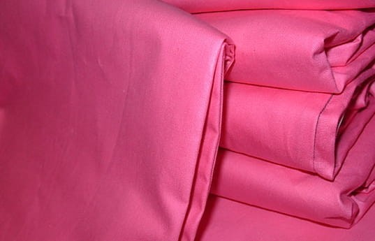 Poszewka wsypowa 70x80 w intensywnym różowym kolorze, wykonana z gładkiego materiału. Ułożona w stos, z widocznymi, starannie wykończonymi brzegami. Prostokątny kształt akcentuje jej rozmiar. Idealna do dekoracji poduszek w sypialni.